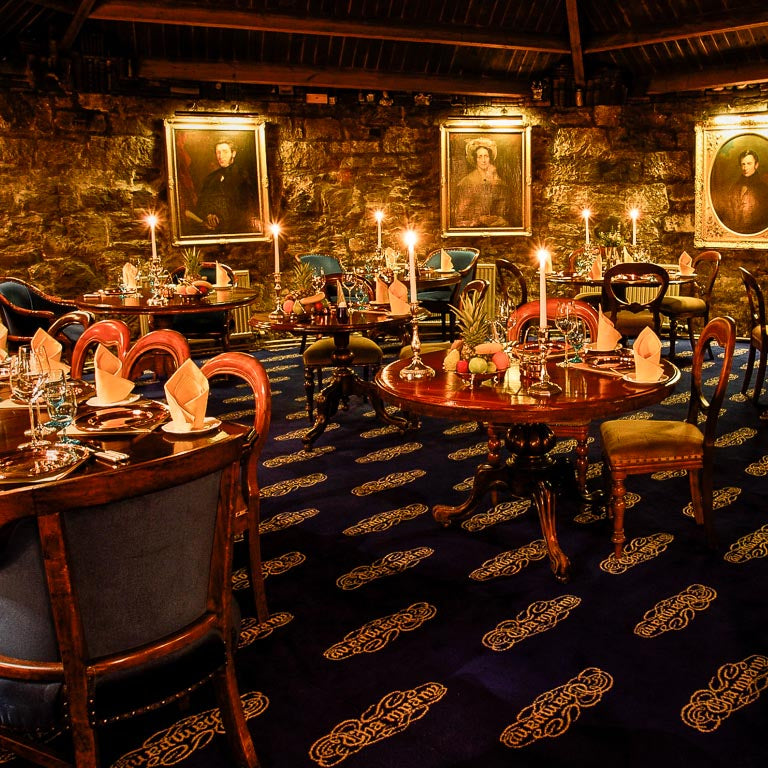 Dining area with tables, chairs, and decorative elements in a cozy setting.