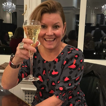Woman holding a glass of champagne in an indoor setting