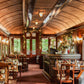 Luxurious train car interior with wooden decor and large windows.